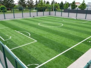 ملعب كرة قدم خماسي بالعشب الصناعي محاط بأسوار